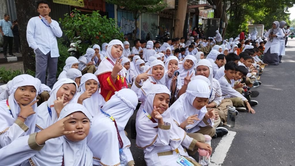 Ratusan siswa sekolah dasar (SD) Muhammadiyah 1 Solo, Jawa Tengah memberikan penghormatan terakhir kepada Raja Keraton Surakarta Paku Buwono atau PB XIII di sepanjang jalan Slamet Riyadi pelepasan jenazah dari Keraton menuju Lokasi transit di Loji Gandrung, Rabu (5/11/2025).