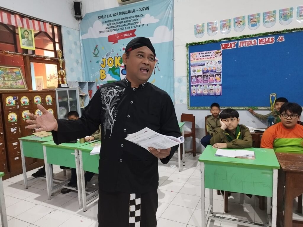 Guru Bahasa Jawa SD Muhammadiyah 1 Ketelan Solo, Ki Agung Sudarwanto, memperagakan teknik membedah geguritan (puisi Jawa) secara mendalam sebagai bagian dari Diseminasi Model Pembelajaran Bahasa Jawa Tahun 2026 yang diselenggarakan di Aula Dinas Pendidikan Kota Surakarta, Jumat (24/7/2026).